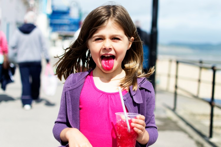 Girl with red tongue after eating a slushy.