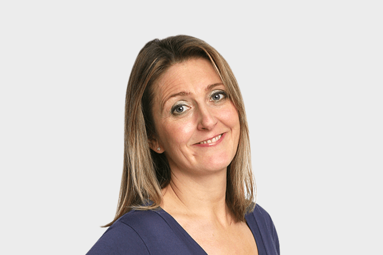 a woman in a blue shirt smiles for the camera